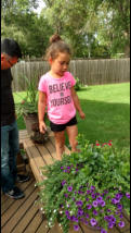Nora checks out flowers. Looking for bugs