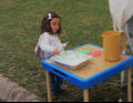 Nora making bubbles at our church booth.